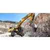 Excavadora SANY SY500H usando martillo hidráulico para demolición de roca en entorno minero.