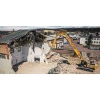 Excavadora SANY SY500HRD demoliendo estructura industrial desde posición elevada.