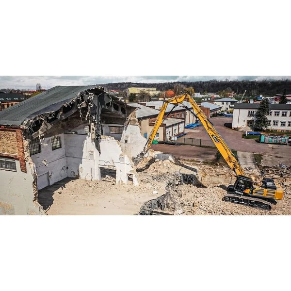 Excavadora SANY SY500HRD demoliendo estructura industrial desde posición elevada.