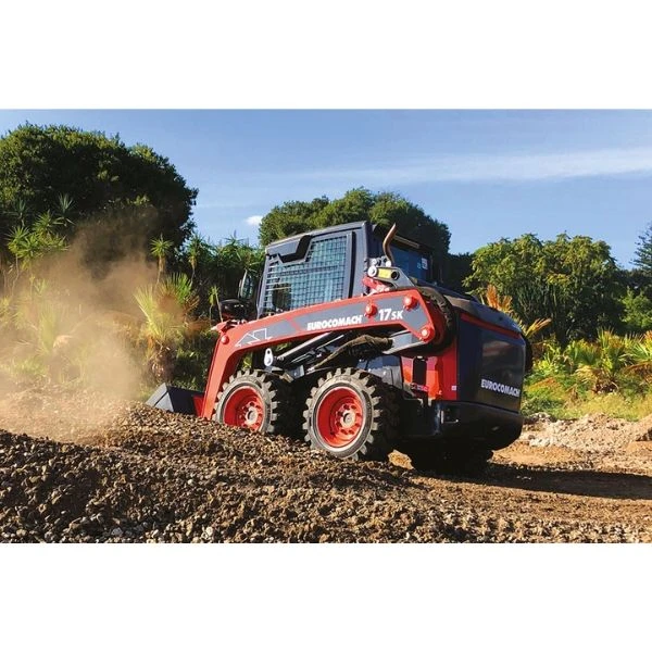 Eurocomach 17SK trabajando en terreno rústico con carga de tierra.