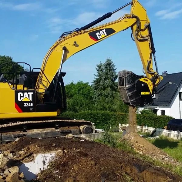 Cuchara trituradora MB BF 80.3 S4 montada en excavadora CAT 324E trabajando en obra urbana.