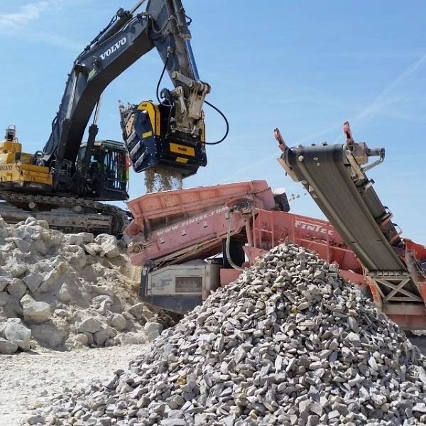 Cuchara trituradora BF135.8 de MB montada en excavadora Hyundai triturando piedra en montaña.
