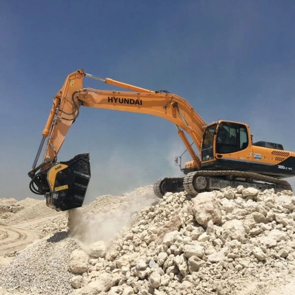 Cuchara trituradora MB BF90.3 S4 operando en cantera blanca con excavadora Hyundai.