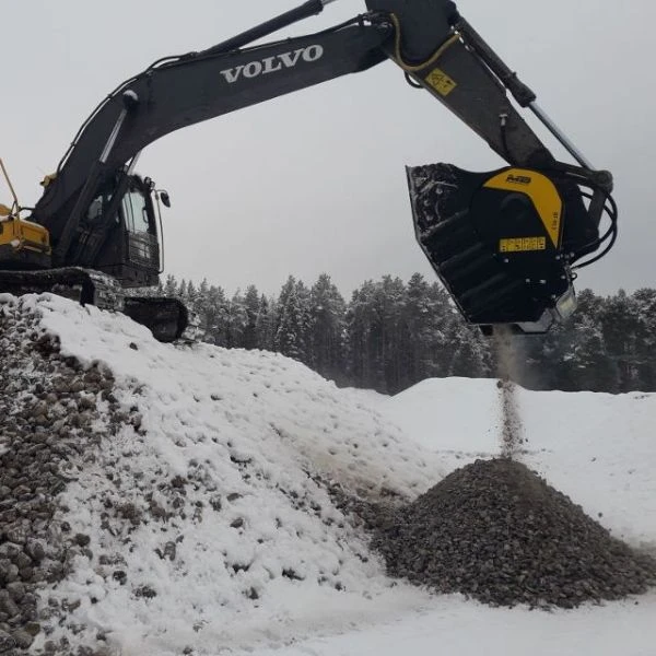 Cuchara trituradora MB BF90.3 S4 trabajando con excavadora Volvo en nieve