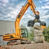 Pinza seleccionadora MB-G1500 S4 apilando bloques de piedra con excavadora, modelos MB-G1200 S4 MB-G1000 S4 MB-G900 S4 y MB-G600 S4 disponibles.