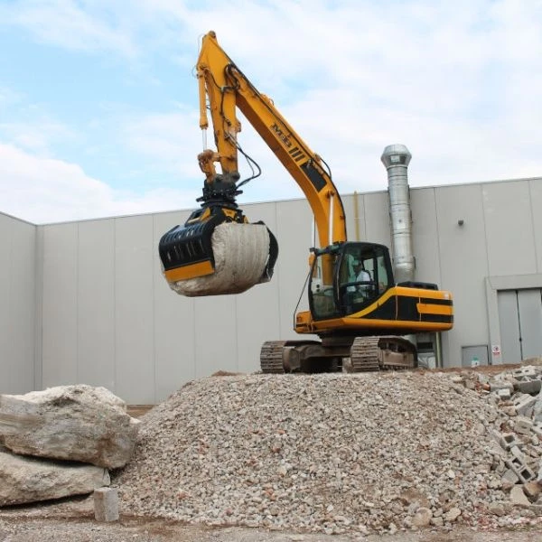 Pinza MB-G1500 S4 elevando bloque de hormigon en obra con excavadora, junto a los modelos MB-G1200 S4 MB-G1000 S4 MB-G900 S4 y MB-G600 S4.