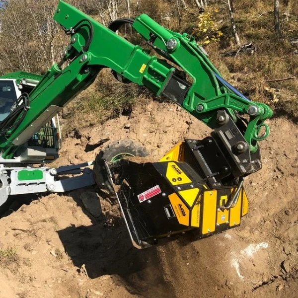 Accesorio MB-HDS214 montado en excavadora trabajando en terreno forestal.