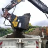 Cuchara seleccionadora MB-HDS314 de MB Crusher acoplada a excavadora descargando tierra cribada.