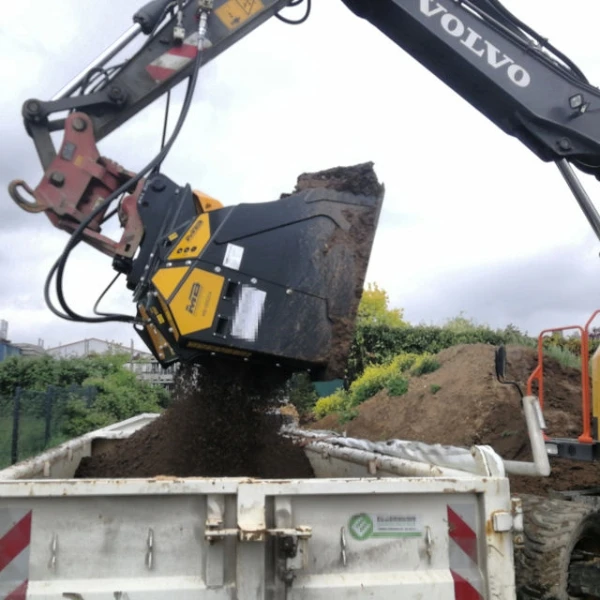 Cuchara seleccionadora MB-HDS314 de MB Crusher acoplada a excavadora descargando tierra cribada.