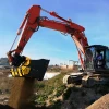 MB-HDS320 de MB Crusher cribando tierra con excavadora sobre campo abierto.