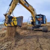 MB-HDS323 de MB Crusher cribando material seco con excavadora CAT en condiciones áridas.