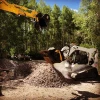 Cuchara trituradora MB L120 S2 triturando escombros con minicargadora Bobcat T300 en obra forestal reduciendo material in situ.
