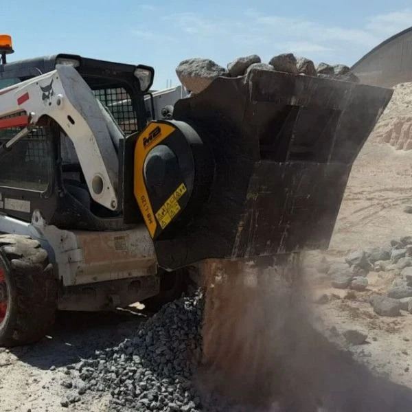 MB-L120 S2 Cuchara Trituradora MB triturando piedra seca con polvo visible en obra.