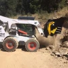 Cuchara trituradora MB-L160 S2 de MB trabajando sobre minicargadora Bobcat en tarea de machaqueo.