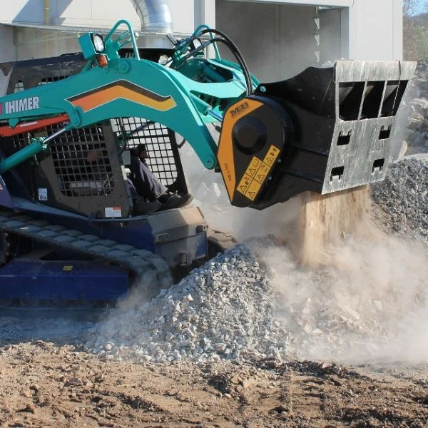 Cuchara trituradora MB-L160 S2 de MB montada en cargadora Ihimer trabajando en trituración de material.