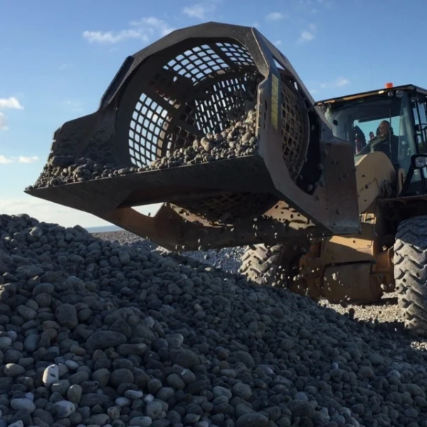 Cuchara Cribadora MB-LS220 S2 cribando piedras con cargadora.