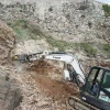 MB-R500 de MB Crusher fresando roca con excavadora Bobcat en entorno escarpado