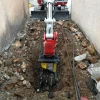 MB-R500 de MB Crusher rozando en zanja estrecha para instalación subterránea.