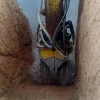 MB-R700 de MB Crusher operando bajo agua con excavadora Kobelco para mantenimiento fluvial.