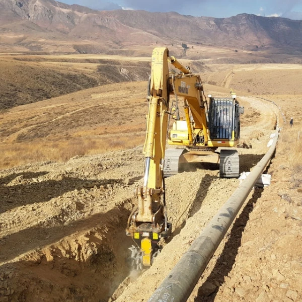 Excavadora JCB con fresadora MB-R800 demoliendo muro vertical de hormigón armado en obra urbana.