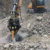 Excavadora con fresadora MB-R900 de MB Crusher trabajando en zona rocosa con fuerte pendiente.