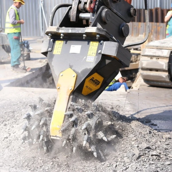 Fresadora MB-R900 de MB Crusher trabajando sobre hormigón en obra con operarios en segundo plano.