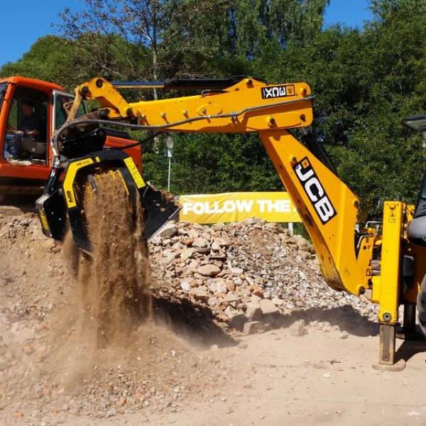 Cargadora trabajando con cuchara MB-S10 S4 en planta de reciclaje industrial.