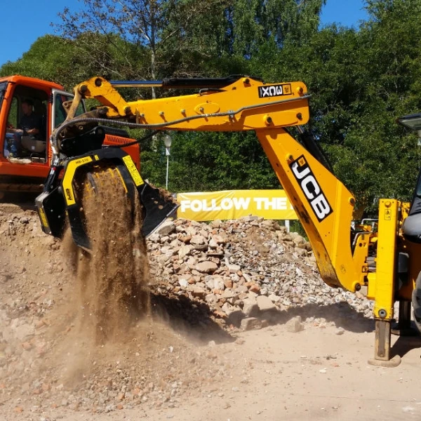 Cargadora trabajando con cuchara MB-S10 S4 en planta de reciclaje industrial.