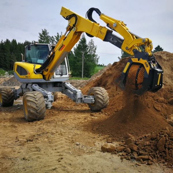 Retrocargadora JCB equipada con cuchara MB-S10 S4 cribando escombros de obra.
