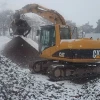 MB S14 S4 cribando materiales con excavadora CAT bajo condiciones de nieve.
