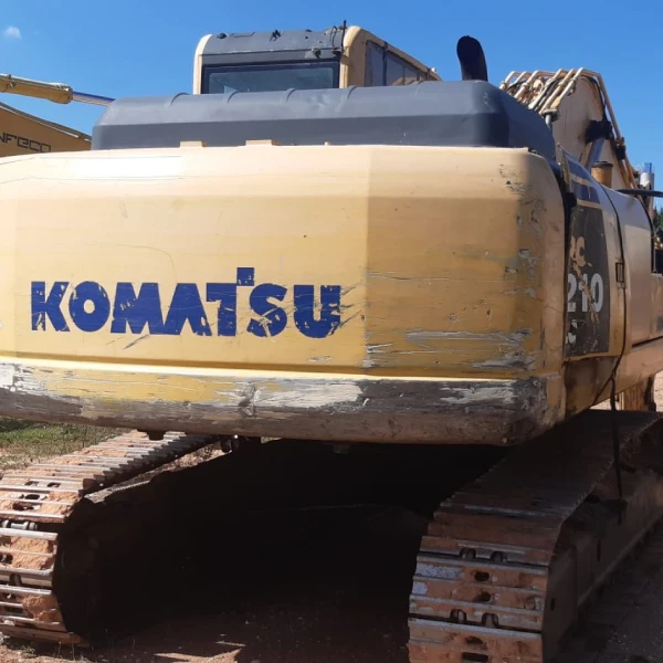 Fotografía destacando las especificaciones de la KOMATSU PC210NLC-8, incluyendo su motor de 116 kW y capacidad de cazo de 1.68 m³.
