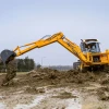 Venieri 10.23E trabajando con su brazo excavador extendido en un terreno fangoso.