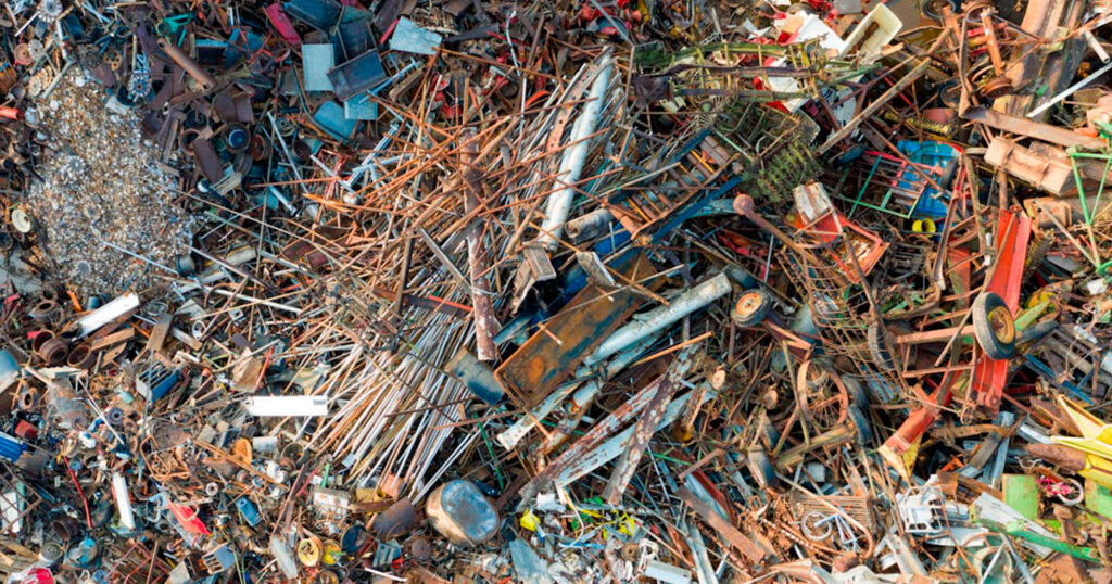 Vista aérea de un centro de reciclaje con residuos metálicos y materiales reciclables, representando la economía circular en acción.