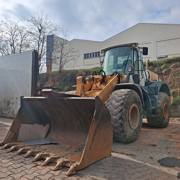 Cargadora Liebherr L-544 con cuchara reforzada en obra de construcción, máquina robusta y eficiente.
