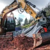Excavadora SANY SY 155U trabajando en terreno inclinado, destacando su potencia y estabilidad.