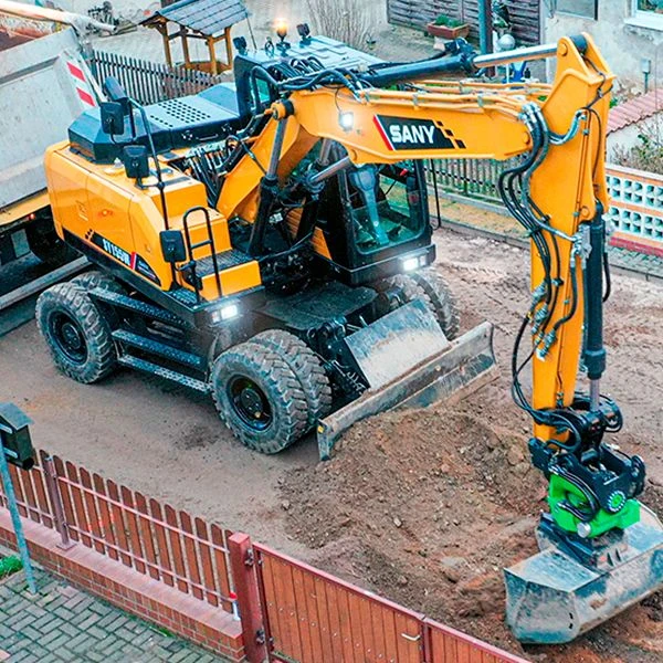 Excavadora de ruedas SANY SY155W trabajando en una obra urbana, destacando su versatilidad y precisión en espacios reducidos.
