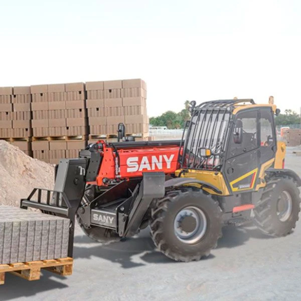 Manipulador SANY STH625E descargando pallet de bloques en obra exterior.