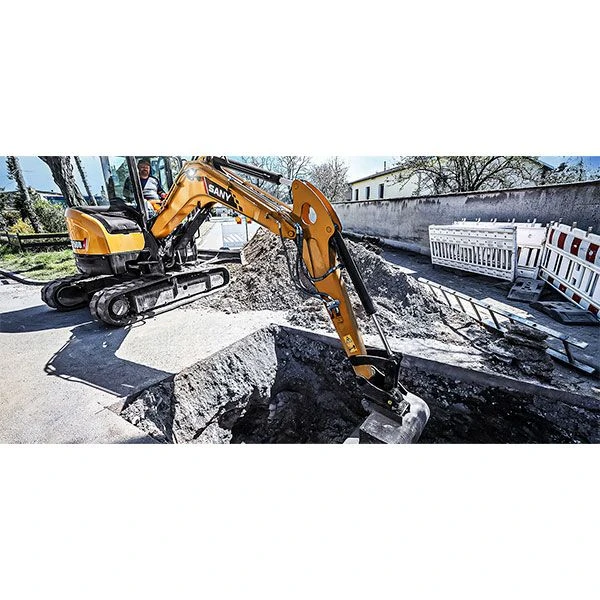 SANY SY50U realizando excavación de zanja en obra urbana.
