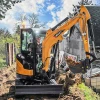 SANY SY26U operando en paso estrecho con cabina cerrada; miniexcavadora de giro 0 ideal para entorno residencial.
