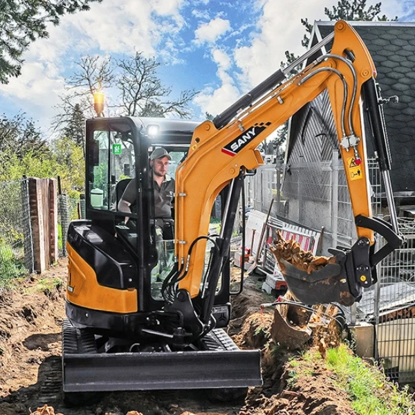 SANY SY26U operando en paso estrecho con cabina cerrada; miniexcavadora de giro 0 ideal para entorno residencial.